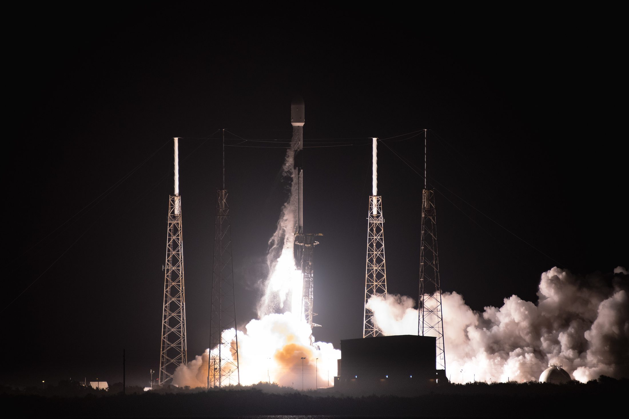 A commercial Falcon 9 rocket launching at night from Cape Canaveral