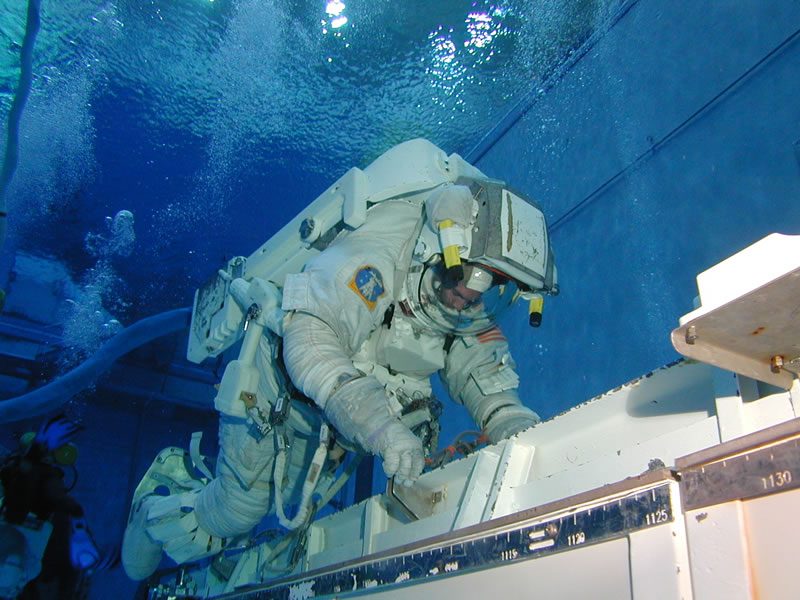 An astronaut candidate climbs into the centrifuge gondola during G-force training — how crews rehearse the acceleration of launch and re-entry