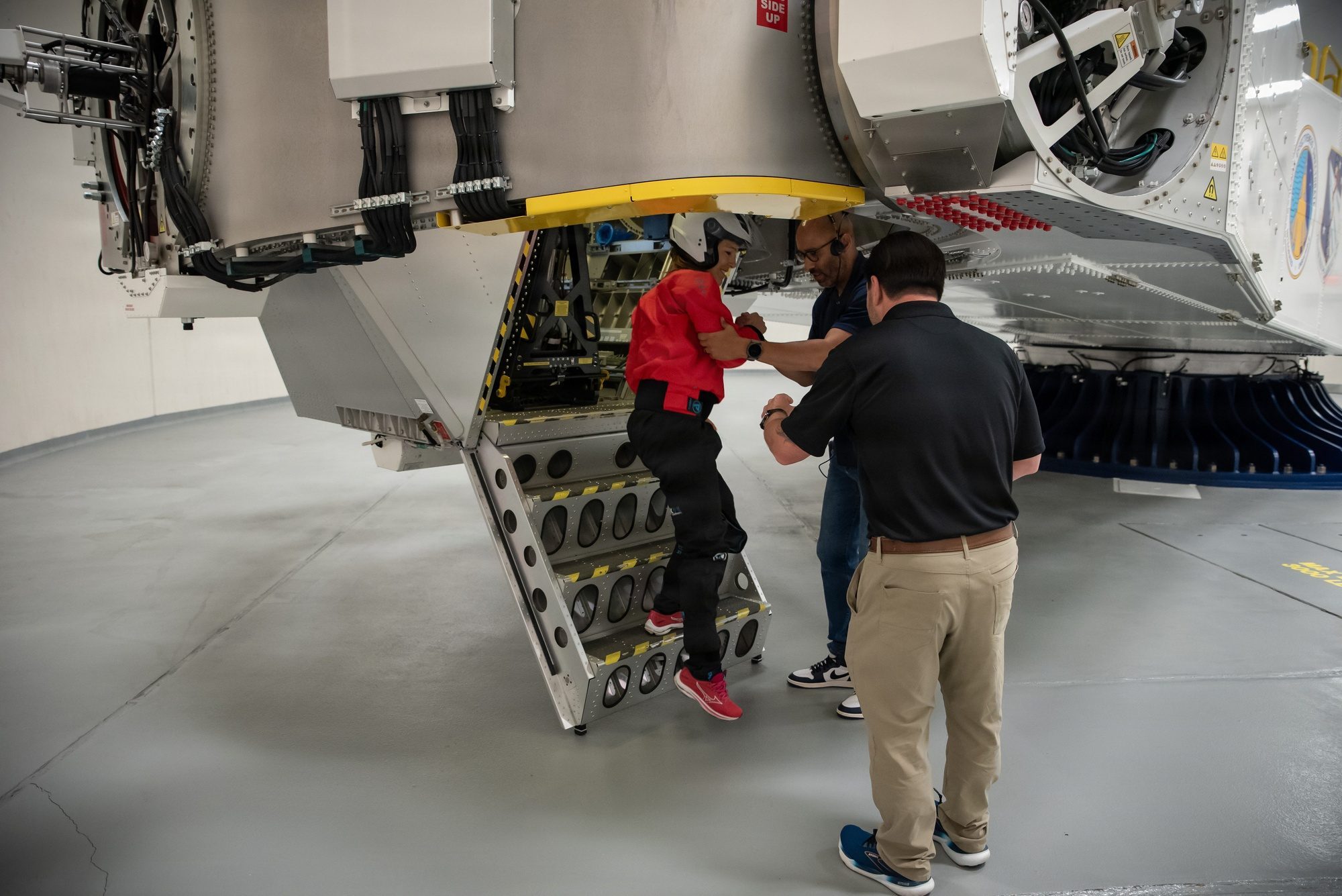 An astronaut candidate climbing into a centrifuge gondola during G-force training