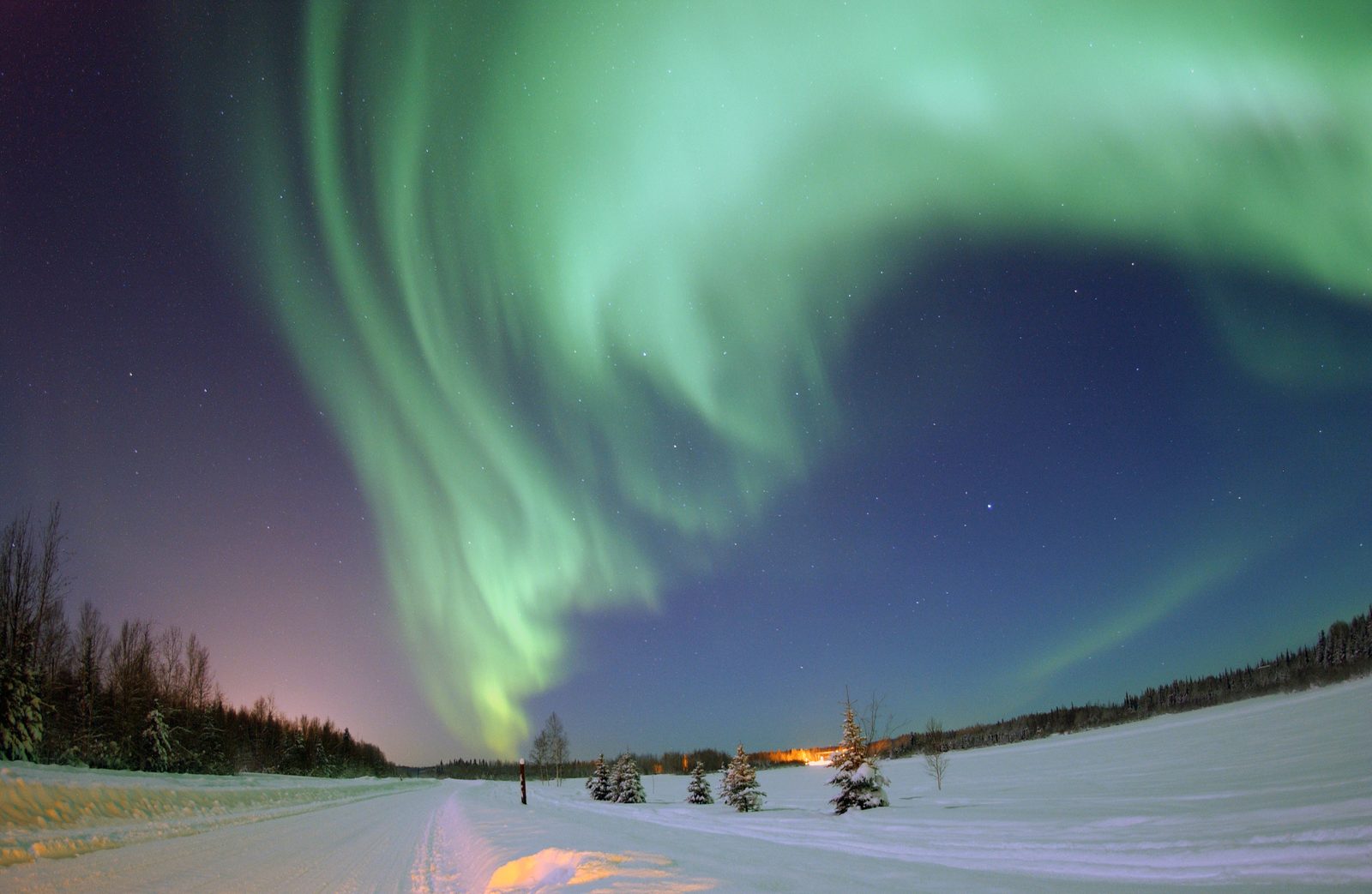 The Aurora Borealis glowing green over Bear Lake at Eielson Air Force Base, Alaska