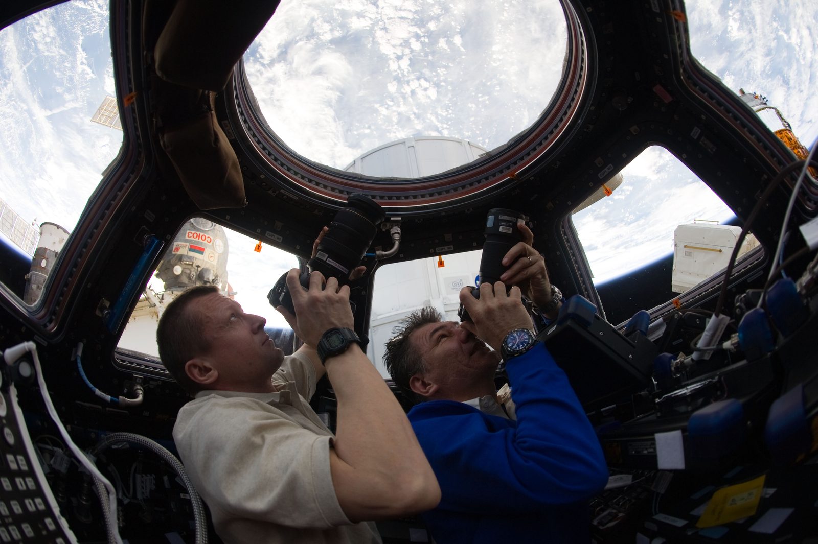 An astronaut works at a spacecraft window — the orbital experience Space Camp’s simulators are built to mimic