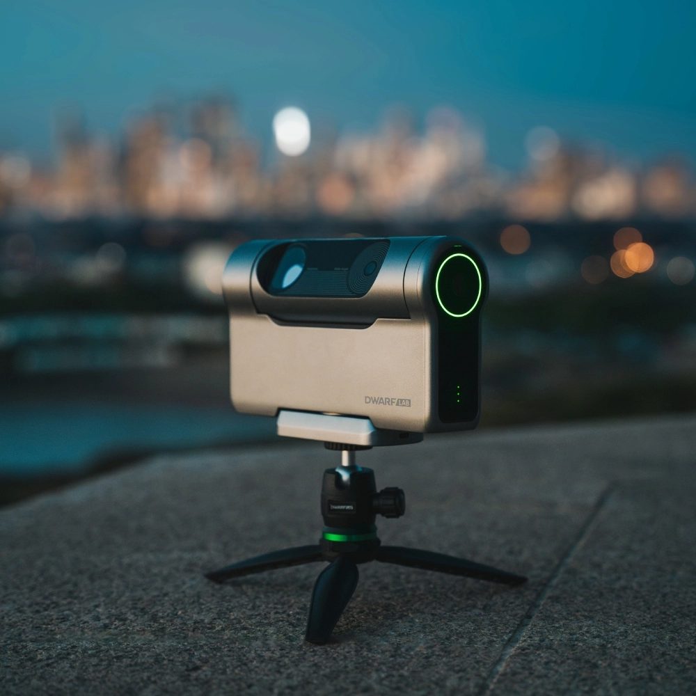 DwarfLab Dwarf 3 smart telescope set up against a light-polluted city skyline at dusk