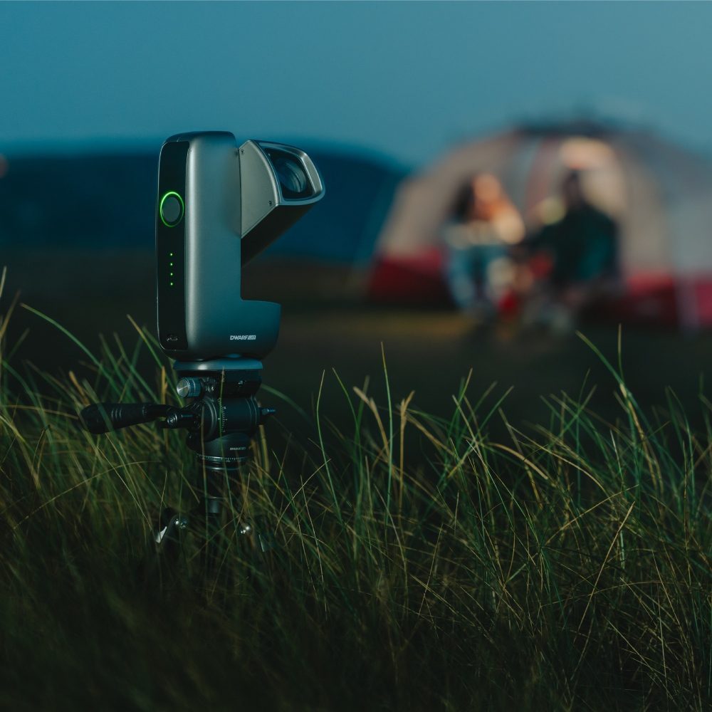 DwarfLab Dwarf Mini smart telescope imaging the night sky beside a lit tent at a campsite