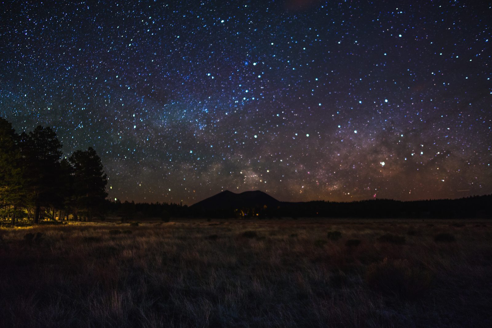 The Milky Way over Sunset Crater, seen across the Bonito Park meadow in the Coconino National Forest north of Flagstaff, Arizona