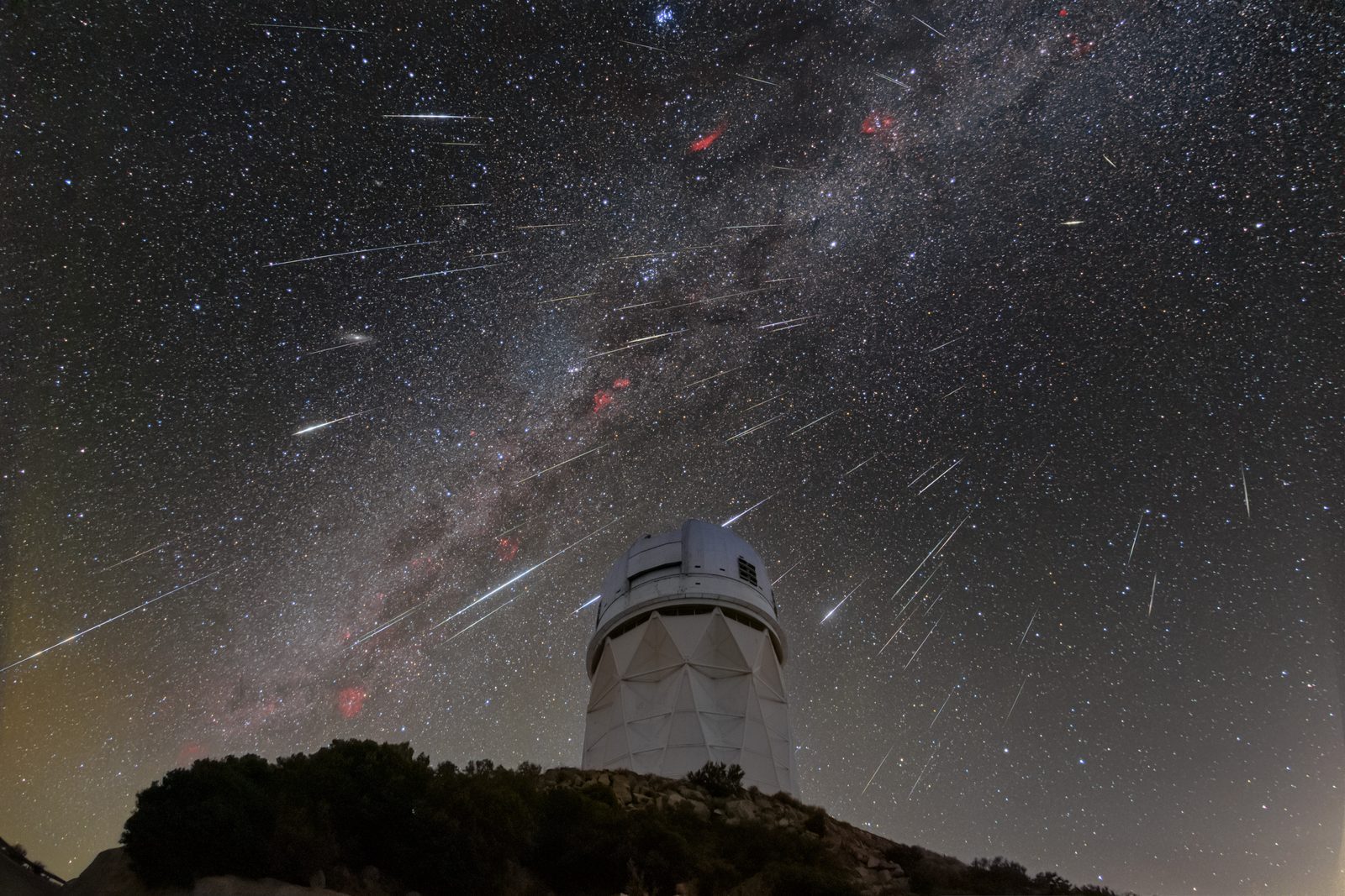 Geminid meteors streaking over the domes of Kitt Peak National Observatory