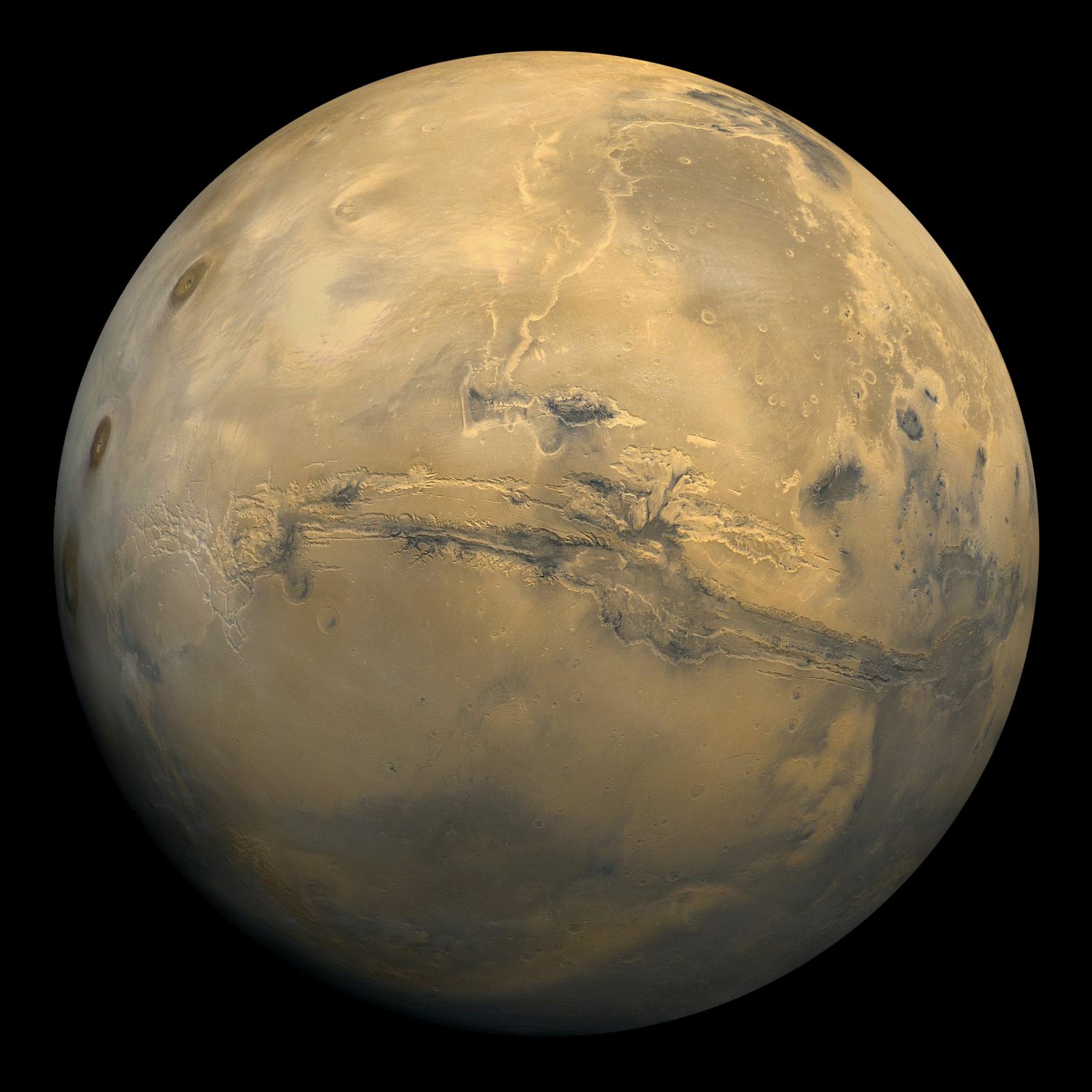 Mars photographed from orbit, showing the rust-colored surface, dark markings and a bright polar ice cap — the features a backyard telescope can resolve at opposition