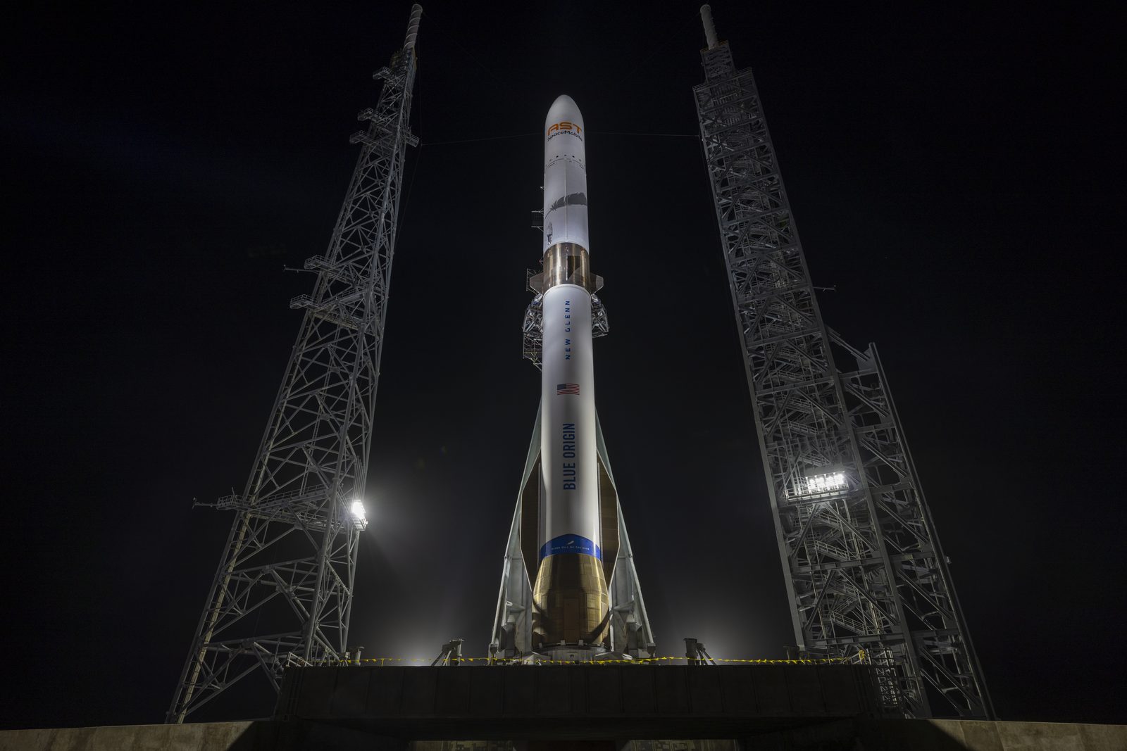 Blue Origin’s New Glenn rocket standing vertical on its launch pad at night