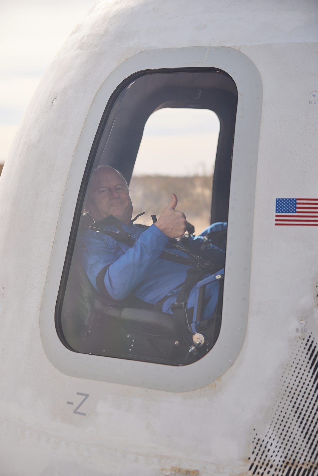 A passenger floating at a spacecraft window during flight