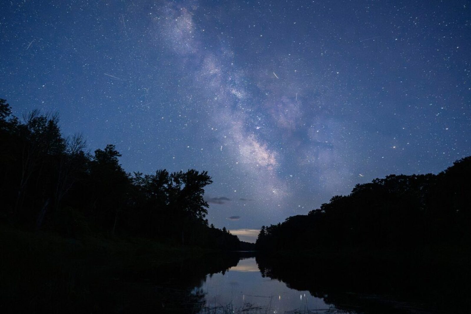 The Milky Way over the East Branch of the Penobscot River at Katahdin Woods and Waters National Monument in Maine — the kind of long-exposure shot a steady, tracking mount makes possible