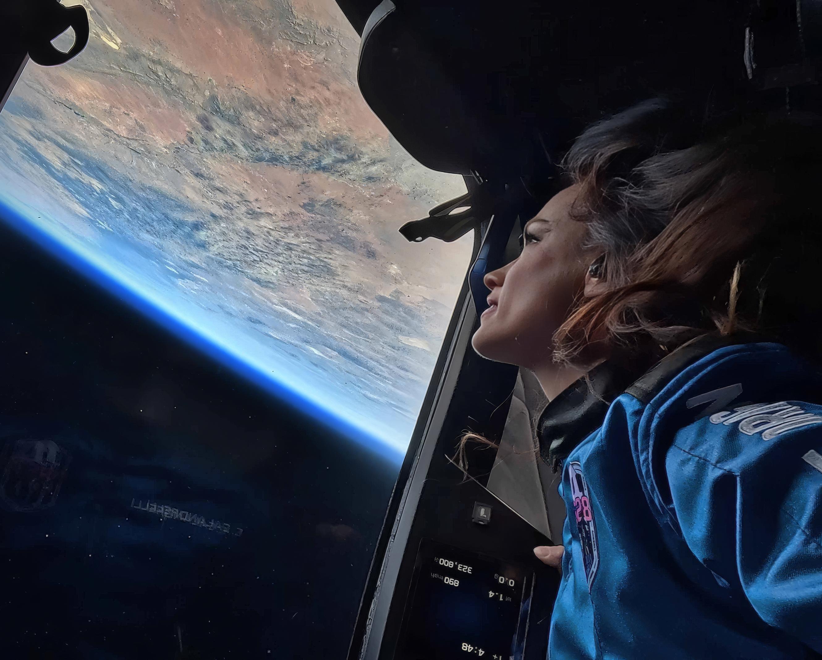 Emily Calandrelli looks out at Earth’s curved horizon through a New Shepard capsule window on Blue Origin’s NS-28 flight