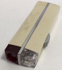 The Sanyo Cadnica Lite rechargeable pilot flashlight, cream-bodied with a red lens on one side and a clear one on the other