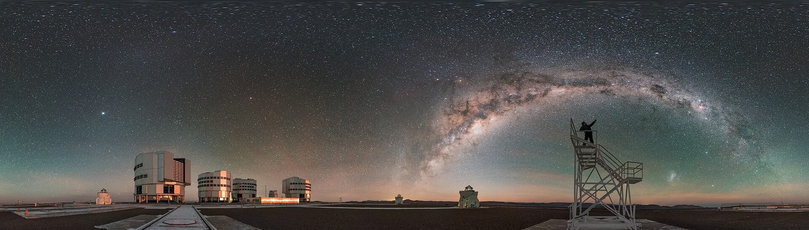 A stargazer silhouetted against the arc of the Milky Way — the sky Leon Palmer built his red flashlight to protect