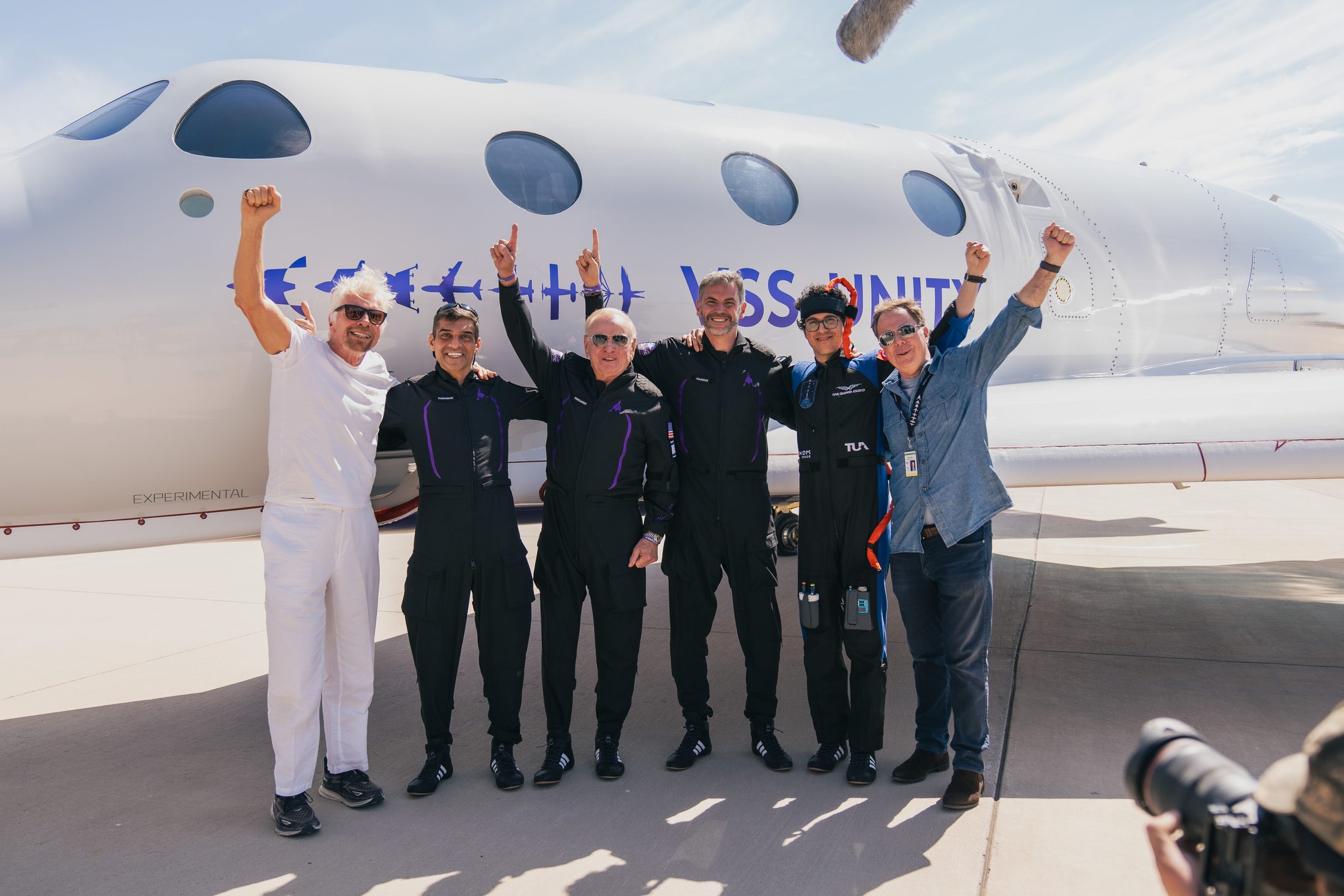 The Galactic 07 crew celebrating beside VSS Unity on the runway after their June 2024 spaceflight