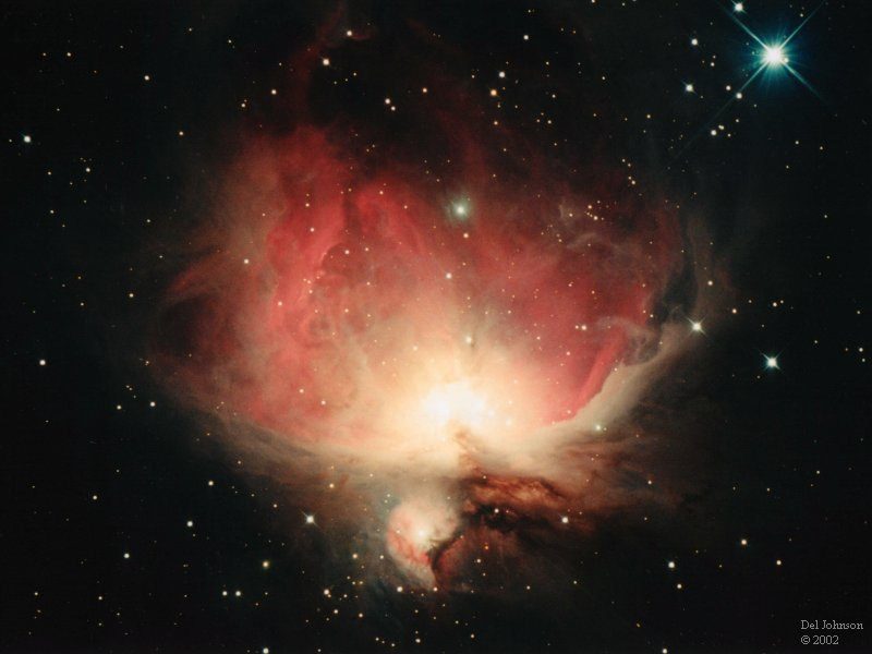 The Orion Nebula in deep red and gold against a black starfield, photographed by Del Johnson in 2002 through a 12.5-inch Zambuto mirror