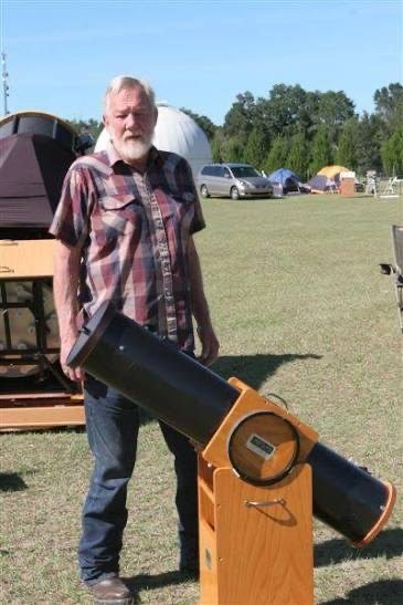 Rick Singmaster of Starmaster Telescopes standing on a star-party field beside the original oak Oak Classic telescope